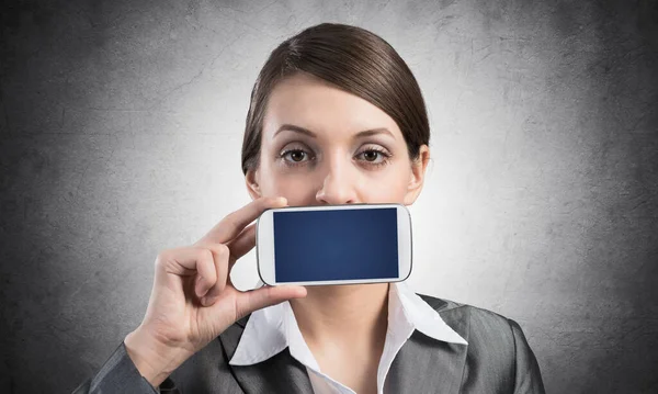 Žena zakrývající si ústa smartphonem — Stock fotografie