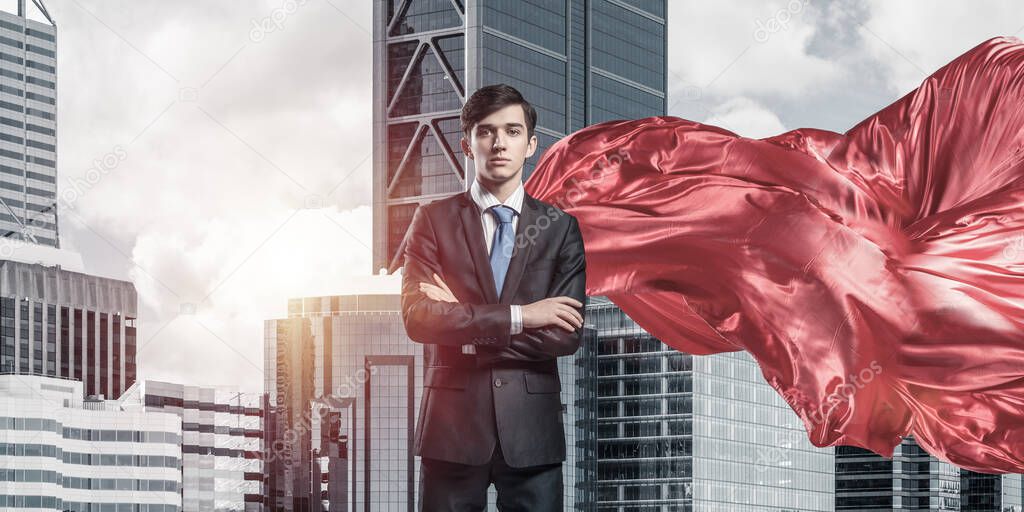 Concept of power and sucess with businessman superhero in big city