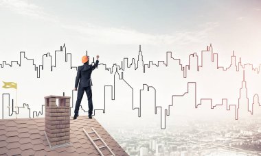 Erkek mimar mavi gökyüzüne modern şehrin siluetini çizer. Karışık