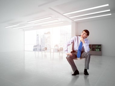 Genç işadamı bir ofis koltuğunda oturuyor.