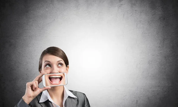 Woman covering her mouth with smartphone — Stock Photo, Image