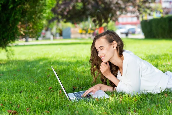 Νεαρή γυναίκα και φορητό υπολογιστή στο πάρκο — Φωτογραφία Αρχείου