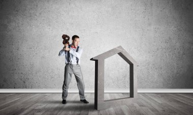 Taştan ev silueti, emlak sigortasının sembolü olarak boş odada.