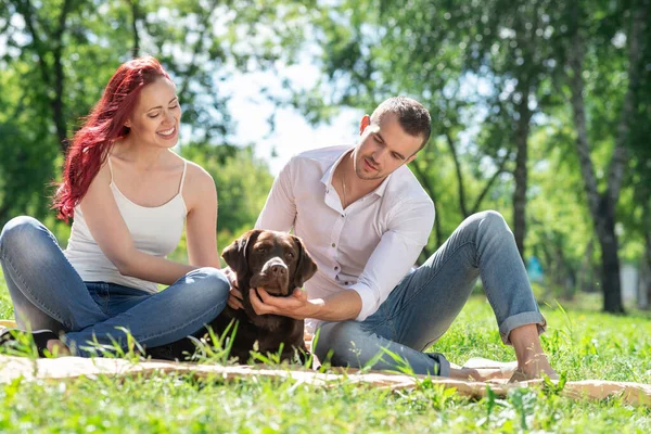 Pareja con un perro en el parque —  Fotos de Stock