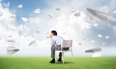 Genç işadamı bir ofis koltuğunda oturuyor.