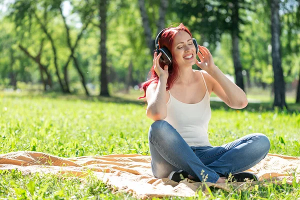 Una joven tiene música en un parque de verano. — Foto de Stock