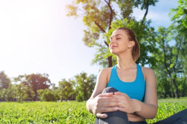 Spor kıyafetli güzel kız parkta rahatla.
