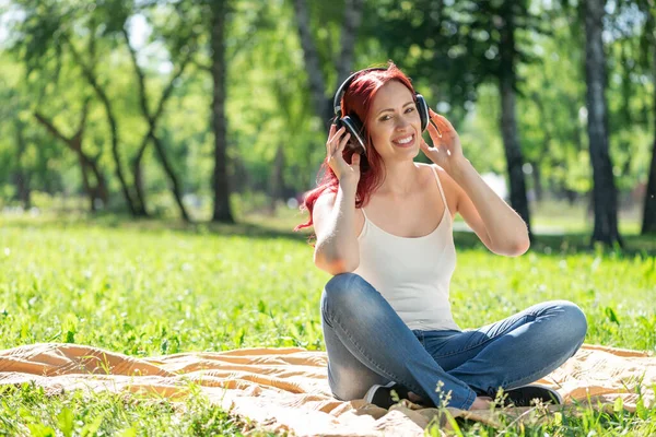 Una joven tiene música en un parque de verano. — Foto de Stock