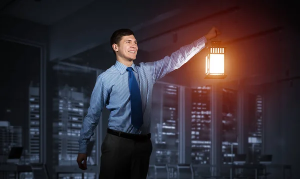 Happy businessman holding glowing lantern — Stok fotoğraf