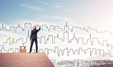 Erkek mimar mavi gökyüzüne modern şehrin siluetini çizer. Karışık