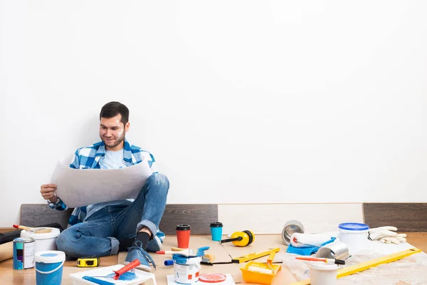 Chico feliz sentado en el suelo con el plano — Foto de Stock