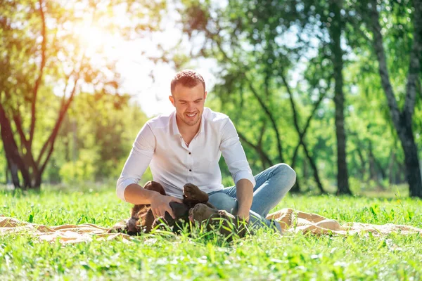Young man with a dog in the park — Stock Photo, Image