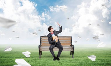 Bankta kitabı olan genç bir öğrenci.