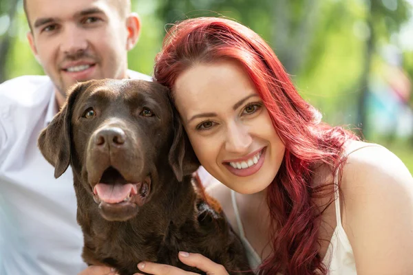 Casal com um cão no parque — Fotografia de Stock