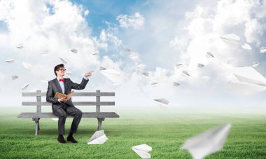 Bankta kitabı olan genç bir öğrenci.