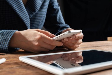 Masada cep telefonu kullanan bir iş kadını.