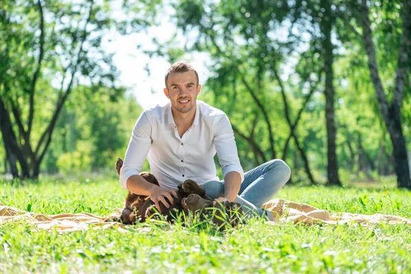 Junger Mann mit Hund im Park — Stockfoto