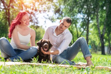 Parkta köpeği olan çift.