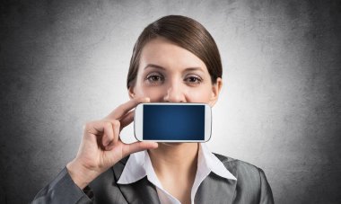 Ağzını akıllı telefonla kapatan kadın.