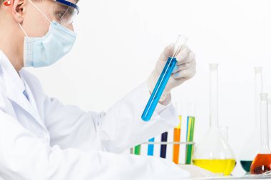 Güvenlik maskesi ve eldivenli laboratuvar teknisyeni.