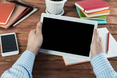 Tabletli bir işadamı, ofiste çalışıyor.