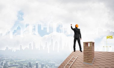 Erkek mimar mavi gökyüzüne modern şehrin siluetini çizer. Karışık ortam