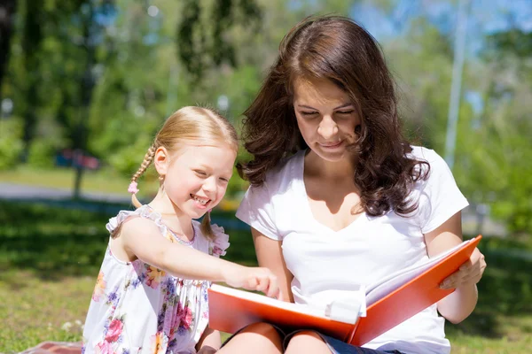 Girl and woman reading book together — Stock Photo, Image