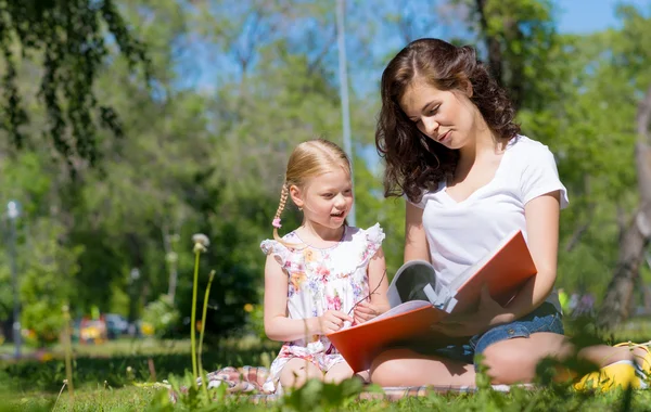 Meisje en vrouw samen met het lezen van boek — Stockfoto