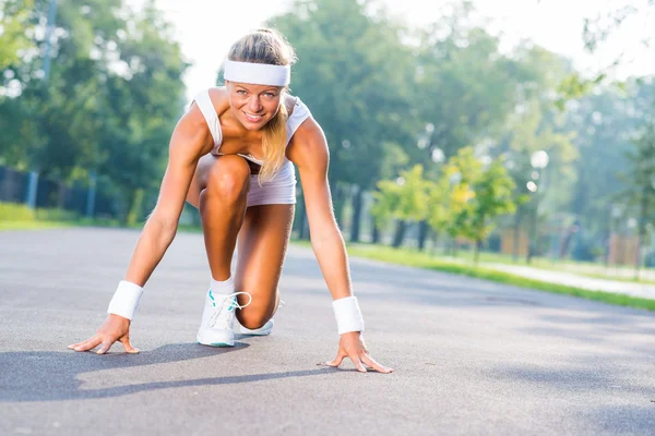 Vrouw loper permanent in start pose — Stockfoto