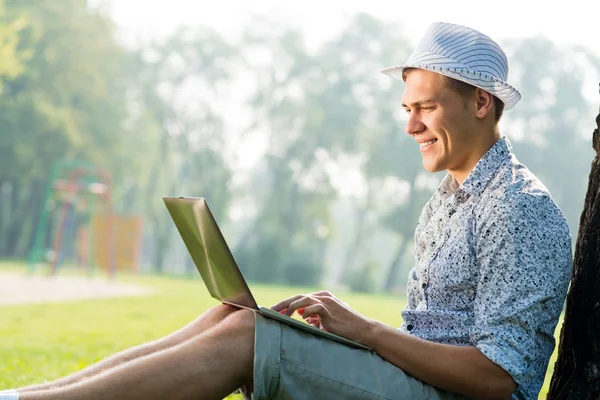 Homme travaillant dans le parc avec ordinateur portable — Photo