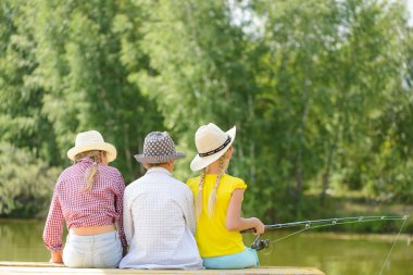 çubuk ile ahşap iskele üzerinde oturan çocuk