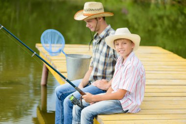 Baba oğul balık tutuyor.