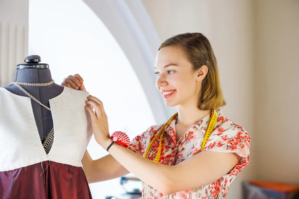 Needlewoman fitting dress on dummy — Stock Photo, Image