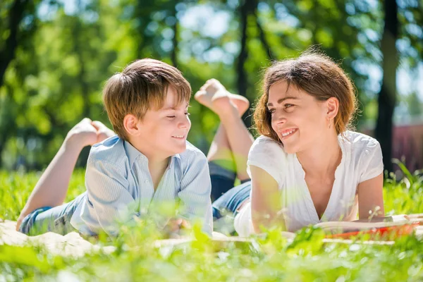 Pojke och ung kvinna i sommaren park — Stockfoto