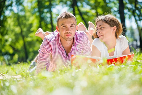 Romantic couple lying in park — Stock Photo, Image