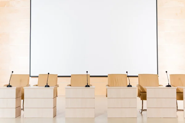 Rangée de sièges avec microphones et tables — Photo