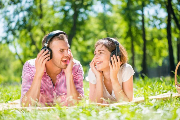 Casal no parque de verão ouvir música — Fotografia de Stock