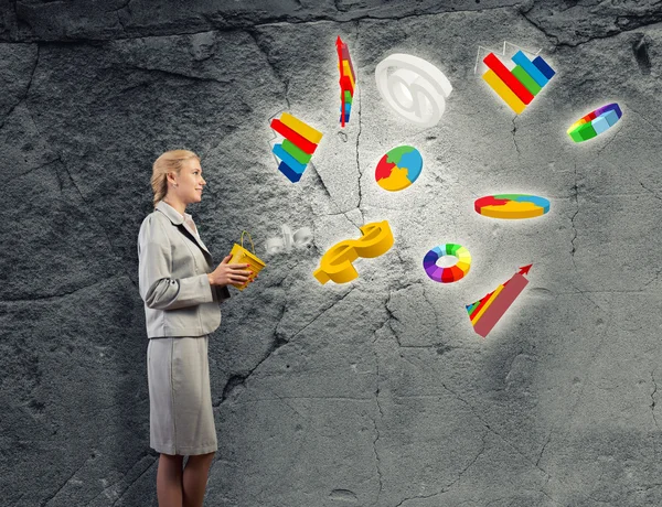 Businesswoman holding bucket with graphs — Stock Photo, Image