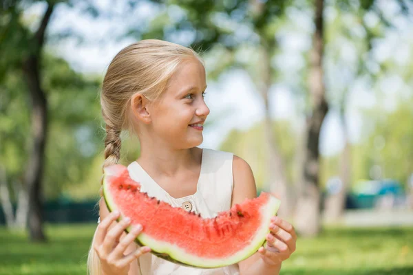 Poika vesimelonin siivulla — kuvapankkivalokuva