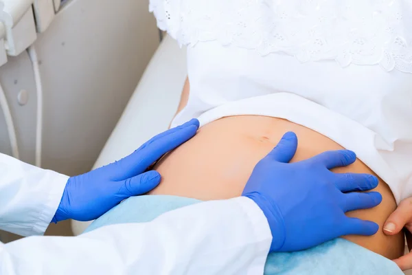 Ręce na brzuchu kobiety w ciąży — Zdjęcie stockowe