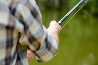 çubuk ile iskele üzerinde oturan adam