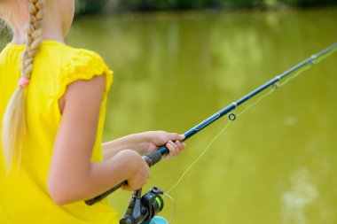 çubuk ile iskele üzerinde oturan kız.