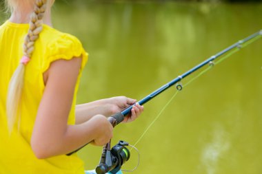 çubuk ile iskele üzerinde oturan kız.