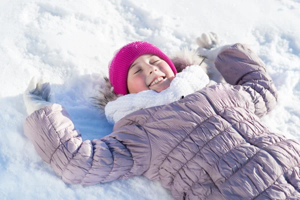 Menina deitada na neve — Fotografia de Stock