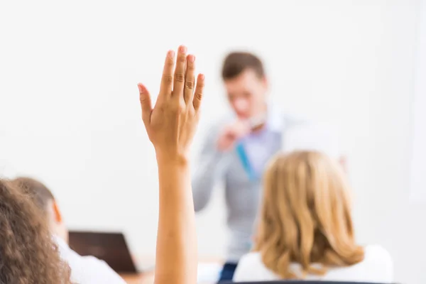 Mano femminile alzata in classe — Foto Stock