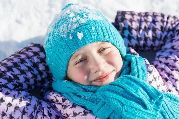 Menina deitada na neve — Fotografia de Stock