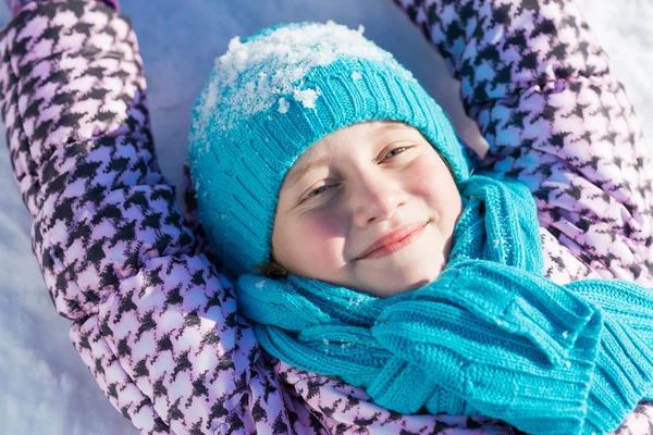 Menina deitada na neve — Fotografia de Stock