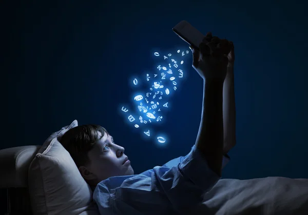 Teenager čtení v posteli — Stock fotografie