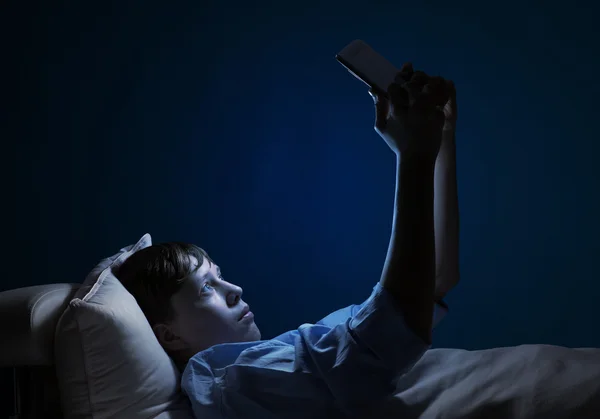 Adolescente leyendo en la cama — Foto de Stock