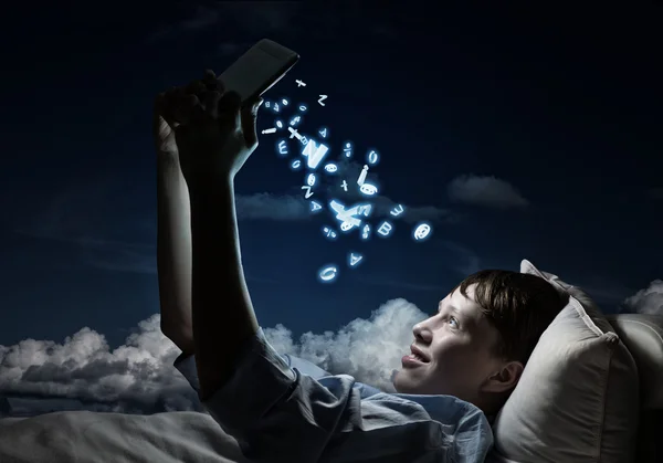 Teenager liest im Bett — Stockfoto